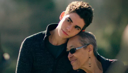 HD wallpaper featuring a heartfelt moment with a young man affectionately embracing an older woman, evoking warmth and family bonds.