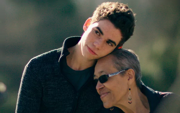 HD wallpaper featuring a heartfelt moment with a young man affectionately embracing an older woman, evoking warmth and family bonds.