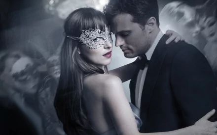 HD wallpaper featuring Jamie Dornan and Dakota Johnson in a dramatic, close embrace from the movie Fifty Shades Darker, with a masked ball setting in the background.