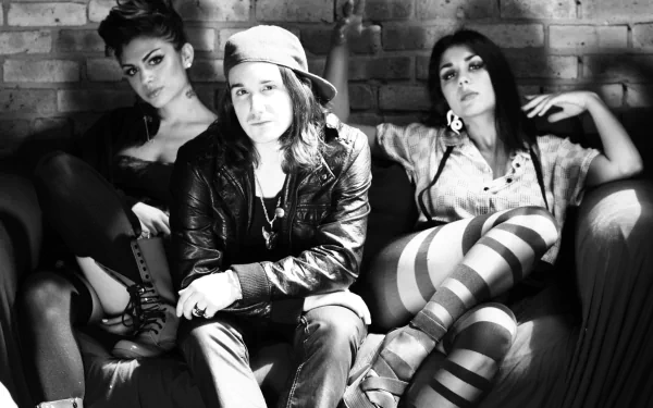 Black and white HD wallpaper featuring music group Krewella, showcasing three members stylishly seated together, exuding a vibe of confidence and artistic flair.