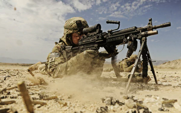 HD desktop wallpaper of a U.S. Army Infantry soldier operating an M249 SAW machine gun in a desert environment.