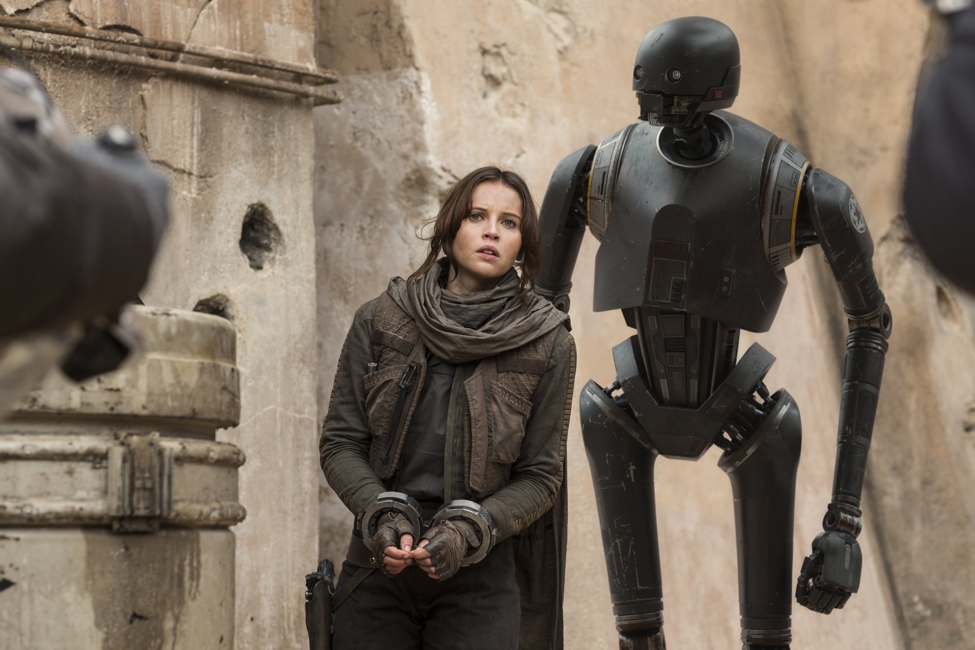 K-2SO and Jyn Erso, portrayed by Felicity Jones, stand together in a scene from the movie Rogue One: A Star Wars Story, captured in 4K Ultra HD.