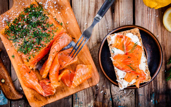 Close-up of smoked salmon on toast with herbs and cream cheese, styled as a still life seafood dish on a wooden board, captured in 4K Ultra HD for desktop wallpaper.