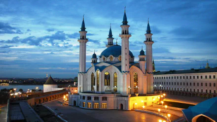 HD wallpaper of a stunning mosque illuminated at dusk, featuring intricate architecture with four tall minarets against a vibrant evening sky.