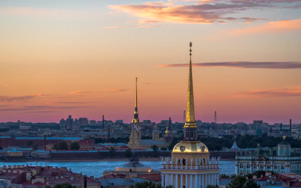 Sunset over the architectural skyline of Saint Petersburg, Russia, showcasing historic city spires along a river under a colorful sky in 4K Ultra HD quality.