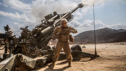 Soldier operating an M777 howitzer artillery piece in a desert landscape, captured in sharp 4K Ultra HD detail.