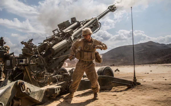 Soldier operating an M777 howitzer artillery piece in a desert landscape, captured in sharp 4K Ultra HD detail.