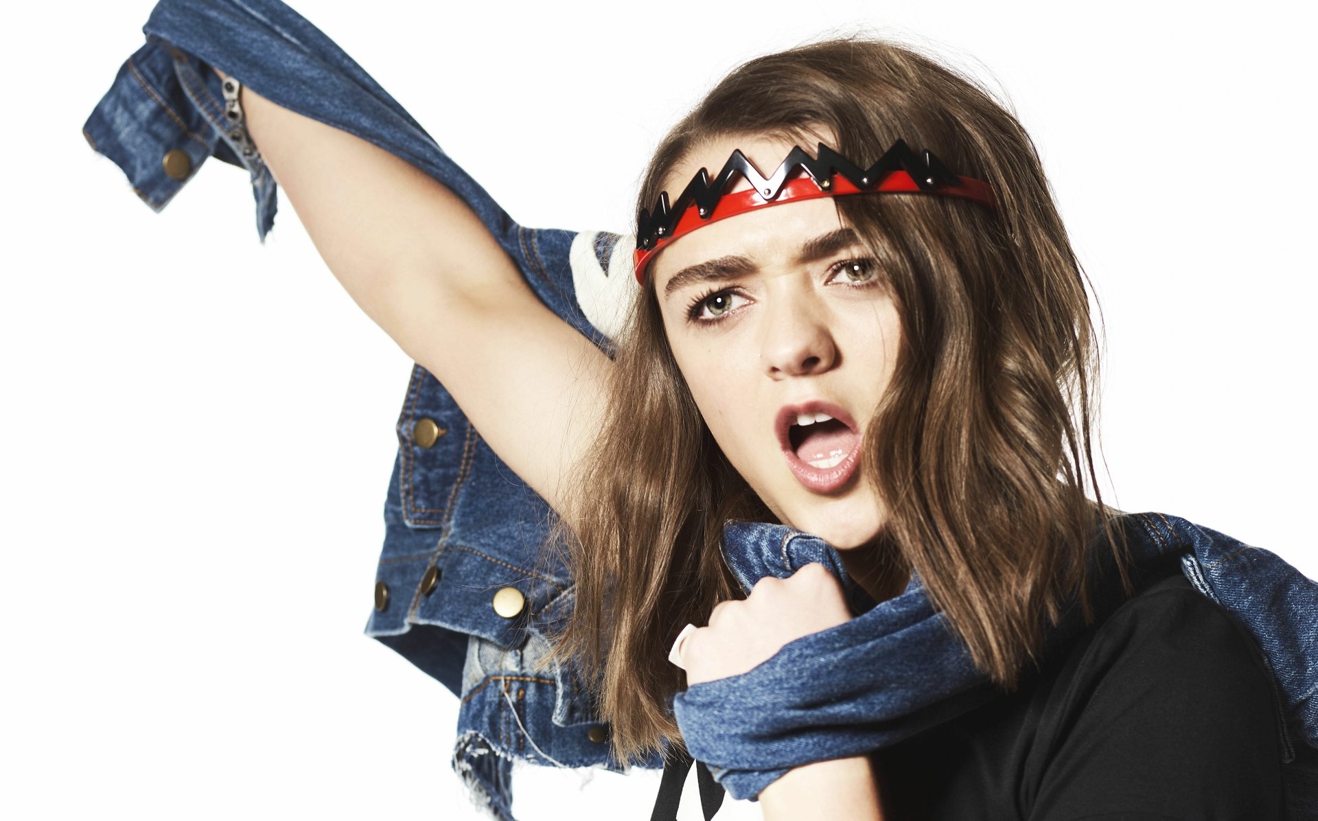 4K Ultra HD wallpaper of British actress Maisie Williams in denim, striking a bold pose with a red and black headband against a white background.