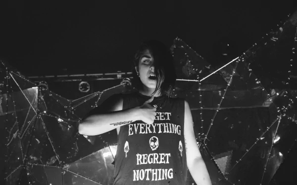 Black and white 4K Ultra HD wallpaper of a Krewella member performing live, wearing a shirt that reads Get Everything Regret Nothing, set against a concert backdrop.