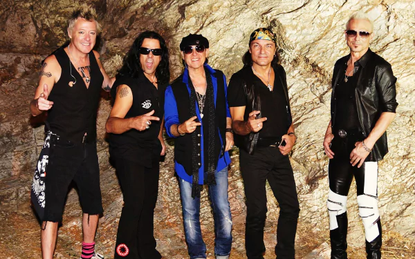 Five band members of the Scorpions posing against a rocky background, featured in an HD desktop wallpaper.