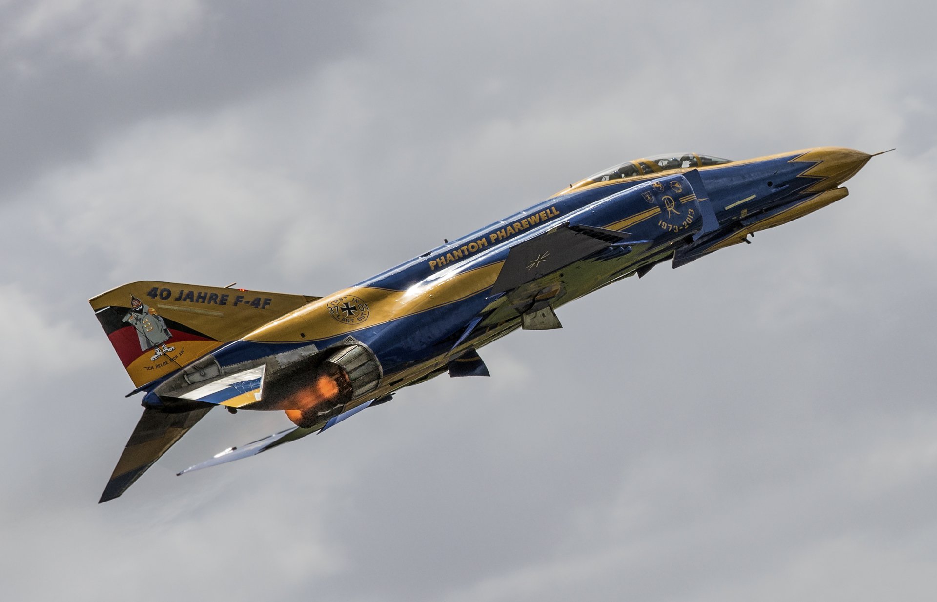 HD desktop wallpaper featuring a McDonnell Douglas F-4 Phantom II jet fighter warplane soaring against a cloudy sky background.