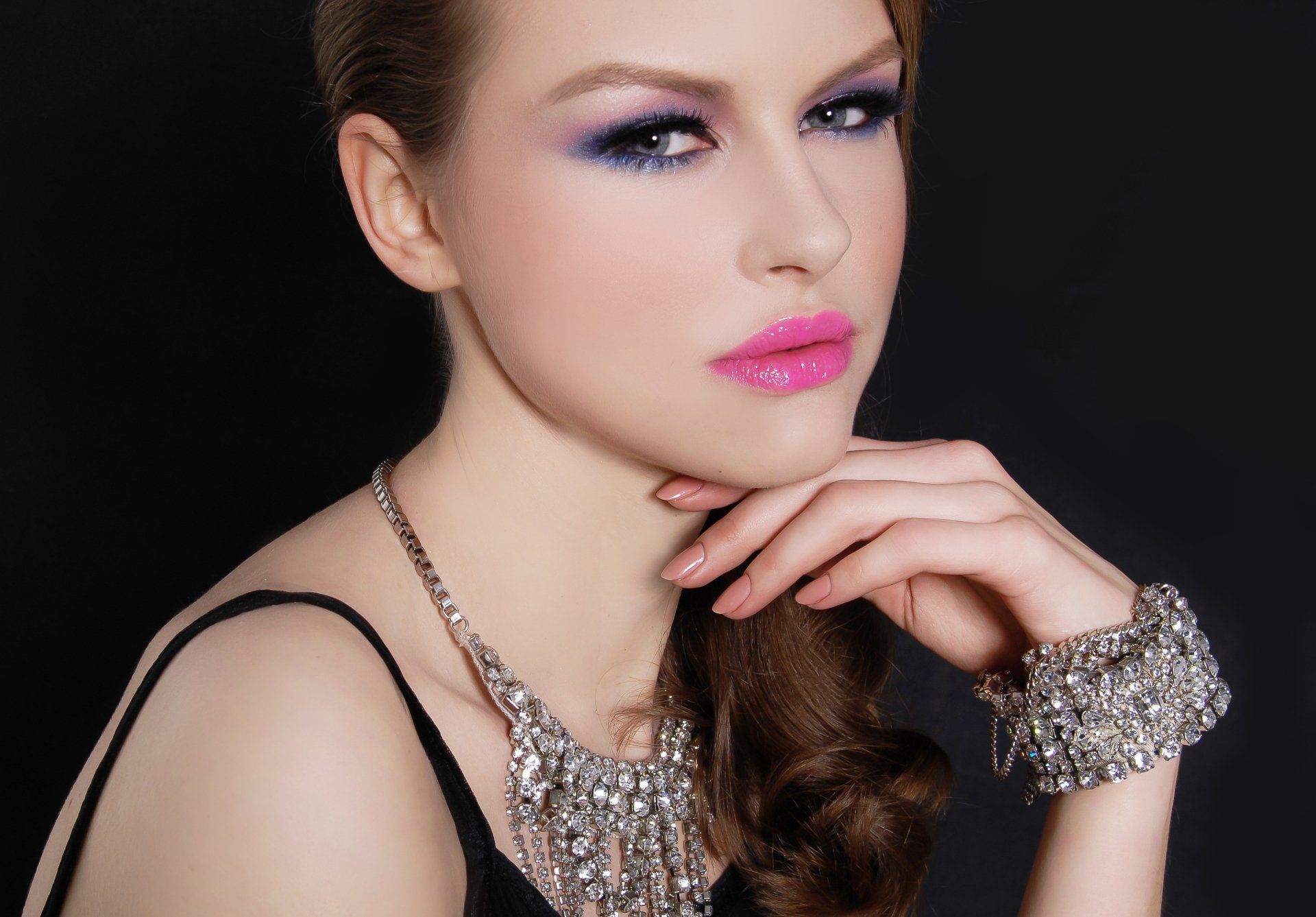 Close-up of a woman model with blue eyes wearing pink lipstick and an ornate necklace and bracelet, featured in a 4K Ultra HD desktop wallpaper background.