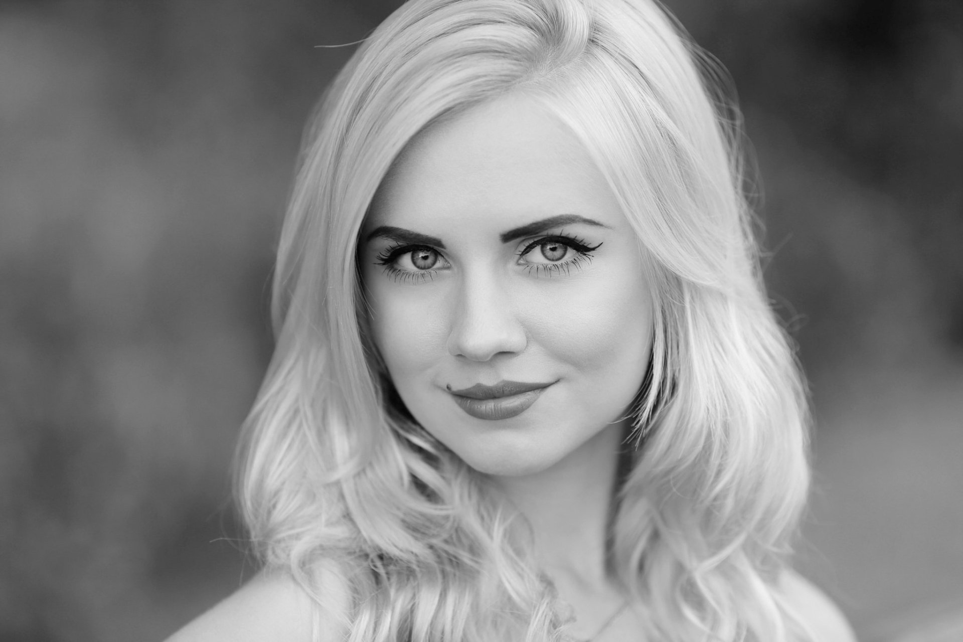 Black and white HD desktop wallpaper featuring a blonde woman with a focused gaze.