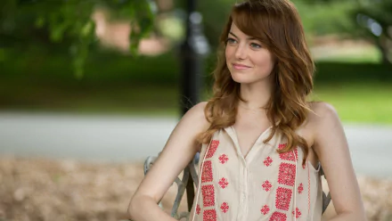 HD desktop wallpaper featuring Emma Stone from the movie Irrational Man, showing her smiling outdoors with a blurred green background.