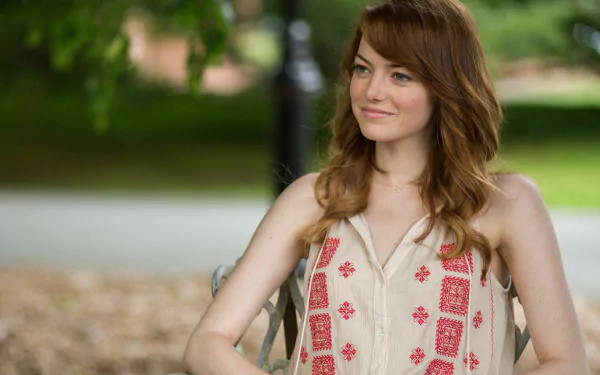 HD desktop wallpaper featuring Emma Stone from the movie Irrational Man, showing her smiling outdoors with a blurred green background.