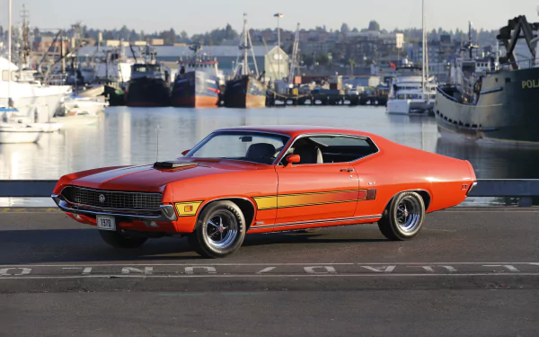 Orange Ford Torino Cobra/GT muscle car vehicle parked by a marina — 5K Ultra HD PC desktop wallpaper and background.