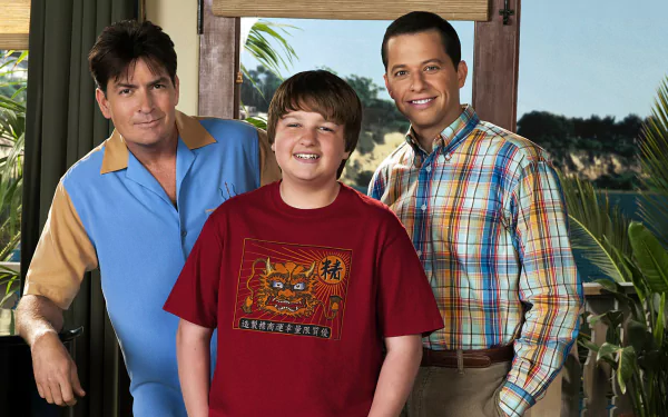 HD desktop wallpaper featuring the main cast of the TV show Two and a Half Men standing together indoors with a scenic outdoor background.