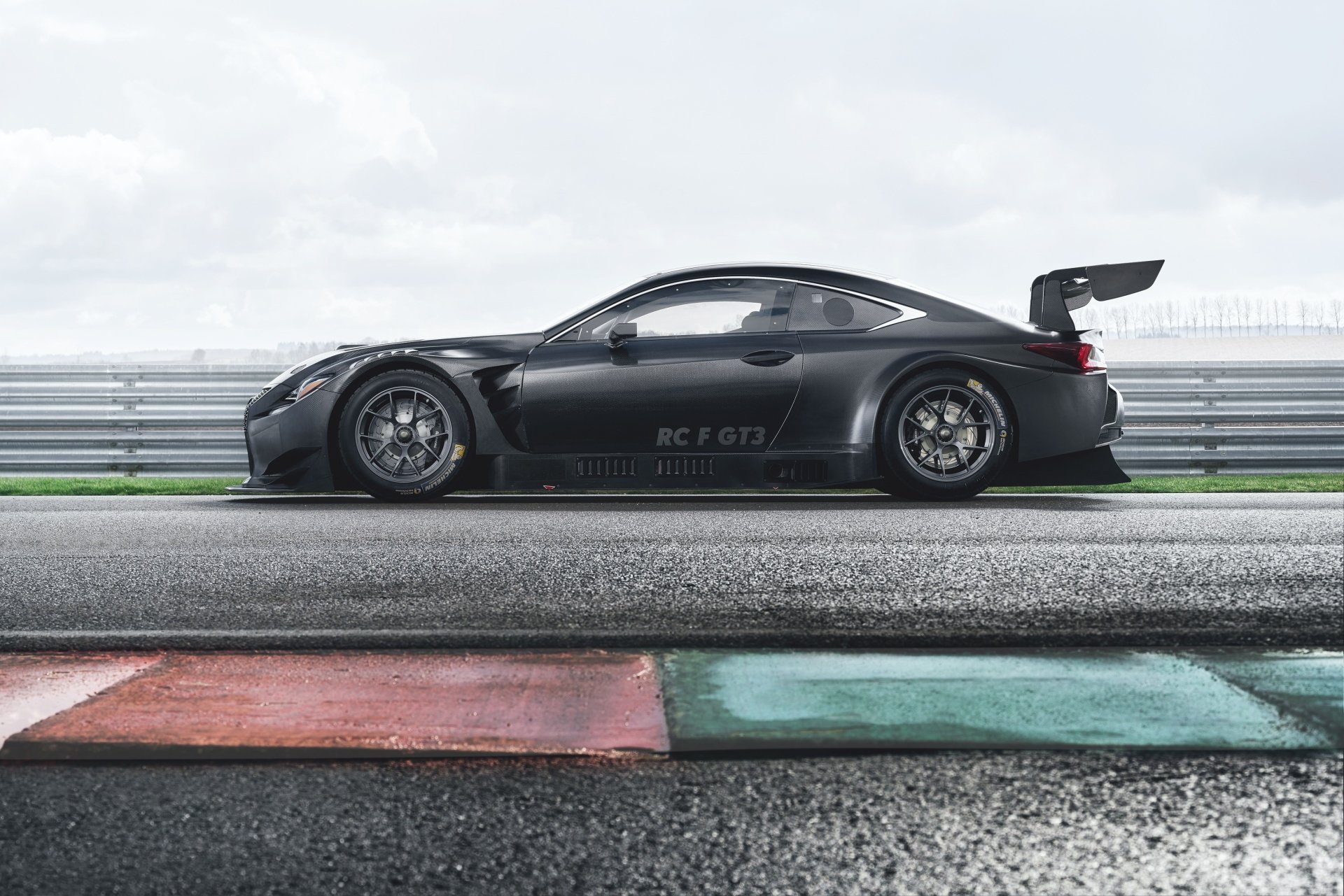 Side profile of a black Lexus RC F GT3 race car (Lexus RC) on a wet racetrack, high-detail 2K Quad HD PC desktop wallpaper background.