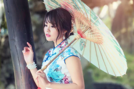 HD wallpaper of an Asian woman with brunette hair and brown eyes wearing a blue kimono and lipstick, holding a traditional umbrella in soft natural light.