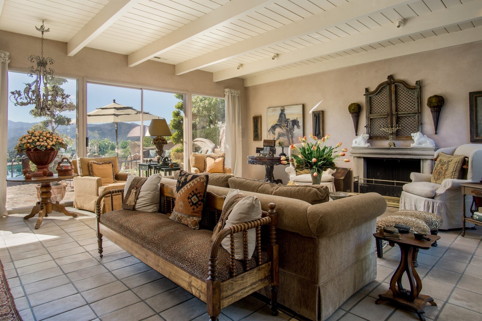 Spacious living room featuring comfortable sofas, a lounge area, elegant furniture, and large windows overlooking an outdoor scene.