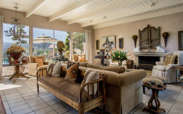 Spacious living room featuring comfortable sofas, a lounge area, elegant furniture, and large windows overlooking an outdoor scene.