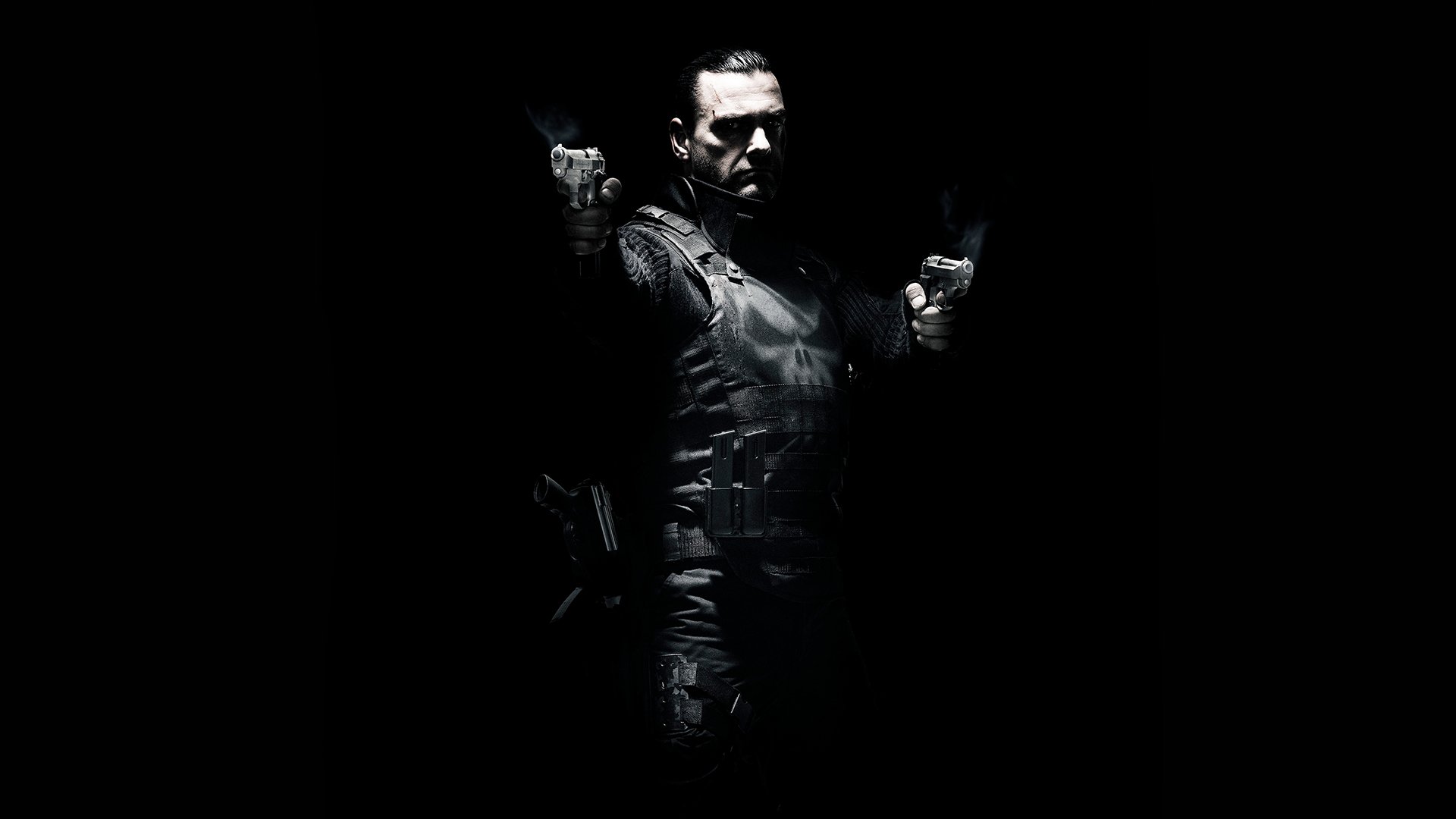 HD PC desktop wallpaper of the movie Punisher: War Zone — the Punisher in tactical armor, dual-wielding pistols, spotlighted against a pitch-black background.
