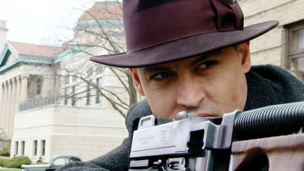 HD PC desktop wallpaper: close-up of an actor in a fedora aiming a Tommy gun outside a stone building, promotional movie image from Public Enemies.