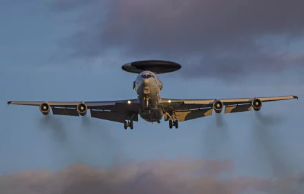 Military Boeing E-3 Sentry aircraft captured mid-flight against a moody sky, presented in stunning 4K Ultra HD quality for PC desktop wallpaper.