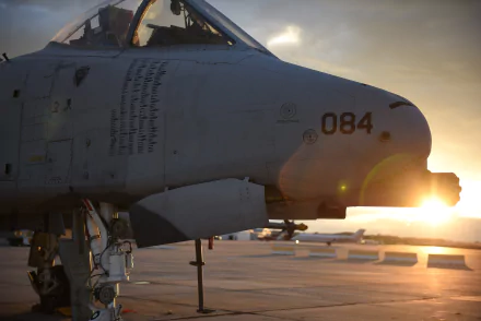 Close-up of a Fairchild Republic A-10 Thunderbolt II jet fighter with gatling gun, set against a dramatic sunset, captured in HD for a desktop wallpaper background.