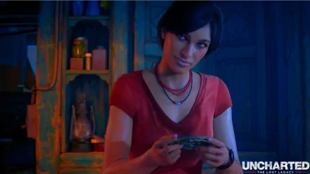 HD PC desktop wallpaper from Uncharted: The Lost Legacy showing Chloe Frazer smiling and holding a small object in a dim, warmly lit room; the game's logo appears at the lower right.