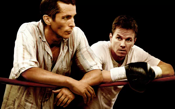 HD desktop wallpaper featuring Christian Bale and Mark Wahlberg in a scene from the movie The Fighter, both leaning on a boxing ring rope.