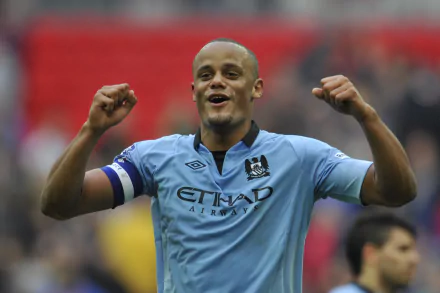 Vincent Kompany celebrating in a Manchester City F.C. jersey during a soccer match, captured in vibrant 4K Ultra HD quality.