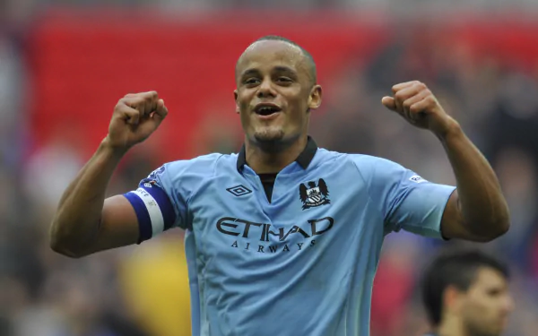 Vincent Kompany celebrating in a Manchester City F.C. jersey during a soccer match, captured in vibrant 4K Ultra HD quality.