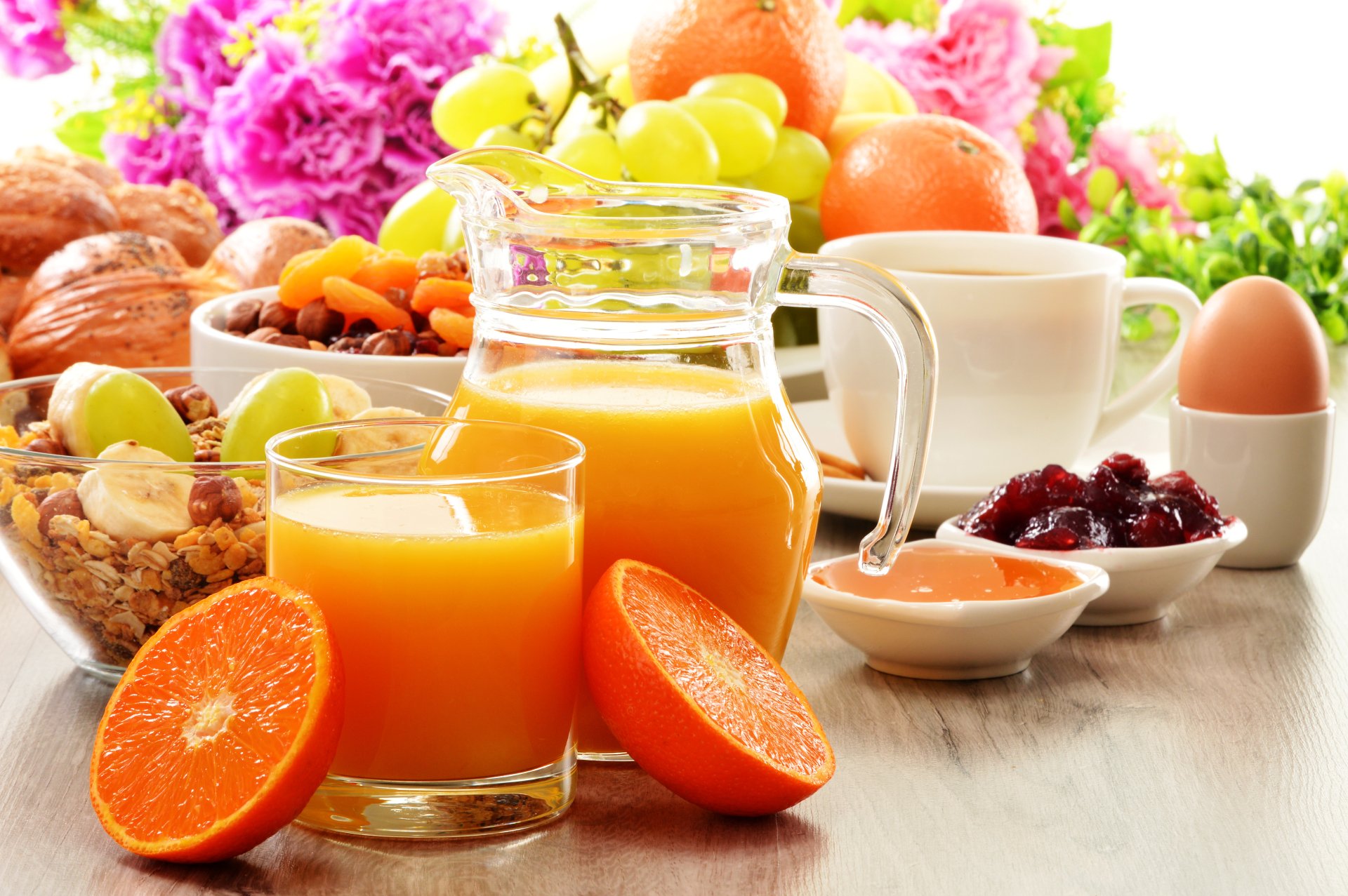 A vibrant 4K Ultra HD breakfast scene featuring muesli, fresh fruit, orange juice, jam, a boiled egg, and a cup of coffee, accented by colorful flowers.