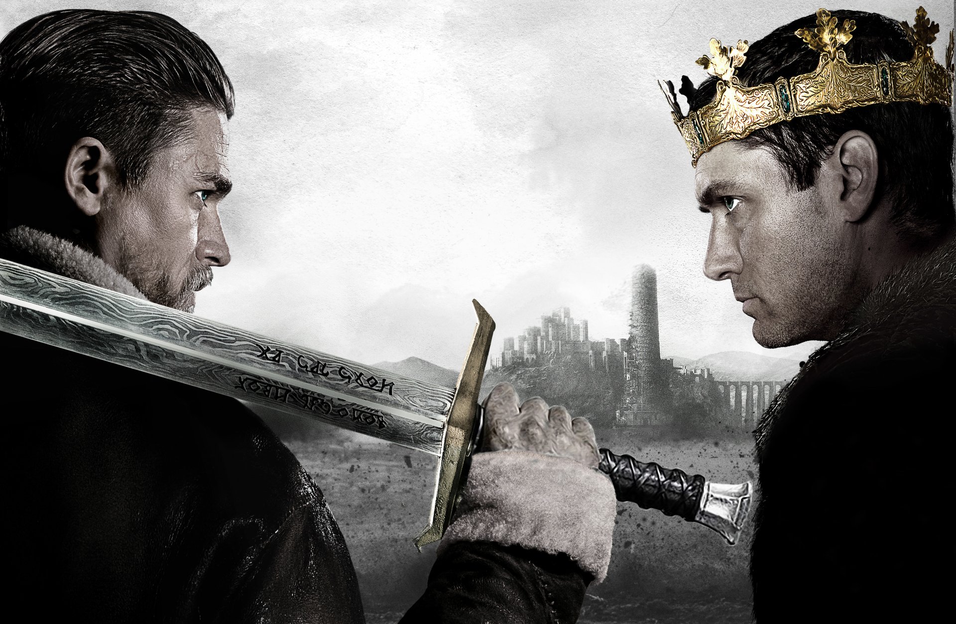 HD wallpaper of Jude Law and Charlie Hunnam in a dramatic confrontation from King Arthur: Legend of the Sword, with a sword and crown, set against a moody backdrop.
