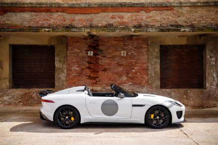 White Jaguar F-Type convertible car/vehicle parked against a weathered brick wall — 4K Ultra HD PC desktop wallpaper background.