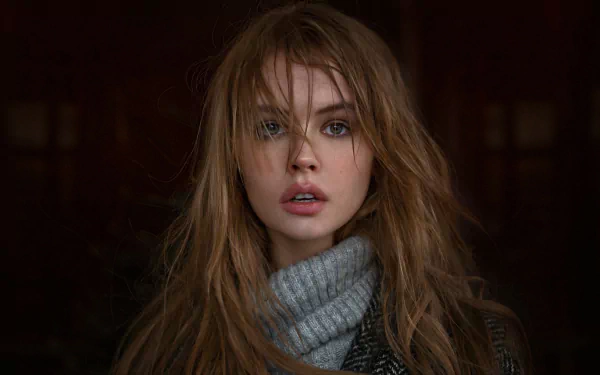 HD desktop wallpaper featuring a brunette Russian model, Anastasiya Scheglova, with tousled hair, wearing a gray turtleneck and leather jacket, gazing directly into the camera.