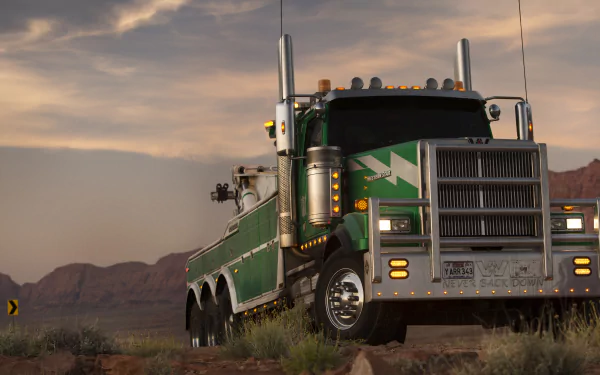 HD desktop wallpaper featuring Onslaught from Transformers: The Last Knight, showcasing an imposing green truck set against a scenic desert backdrop under a cloudy sky.