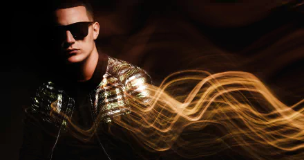 HD desktop wallpaper of a person with sunglasses and a shiny jacket, with golden light trails in the background, tagged with DJ Snake.