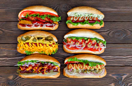 4K Ultra HD PC desktop wallpaper featuring six vibrant hot dogs with various toppings on a wooden background.