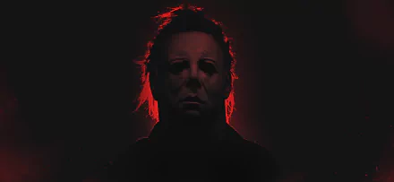 HD desktop wallpaper of Michael Myers from the horror movie Halloween (2007). The silhouette is highlighted with an eerie red glow against a dark background.