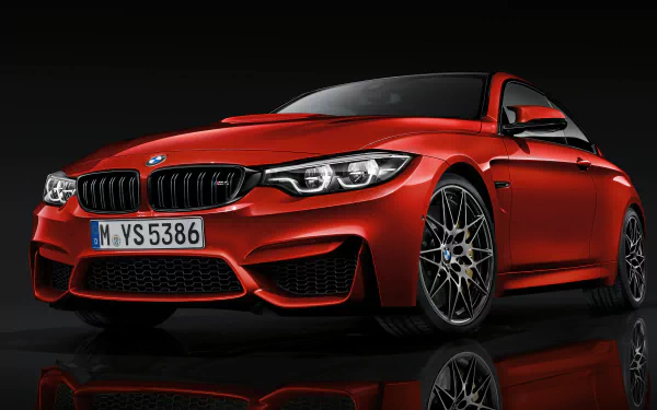 Red BMW M4 Coupe front three-quarter view with glossy reflection on black floor, high-detail 2K Quad HD PC desktop wallpaper.