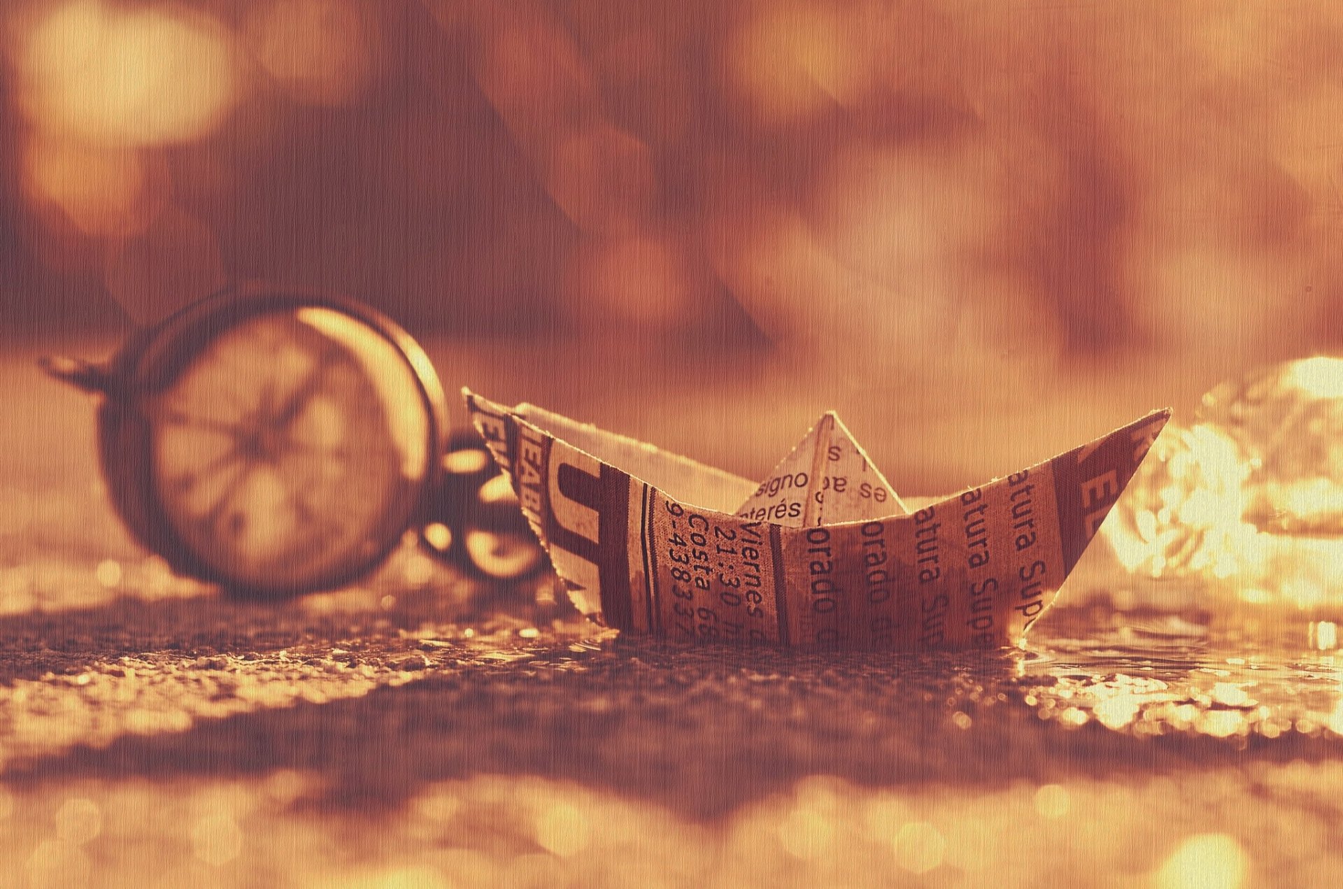 Sepia HD PC desktop wallpaper showing a man-made origami paper boat on a textured surface with a blurred pocket watch and warm bokeh in the background.
