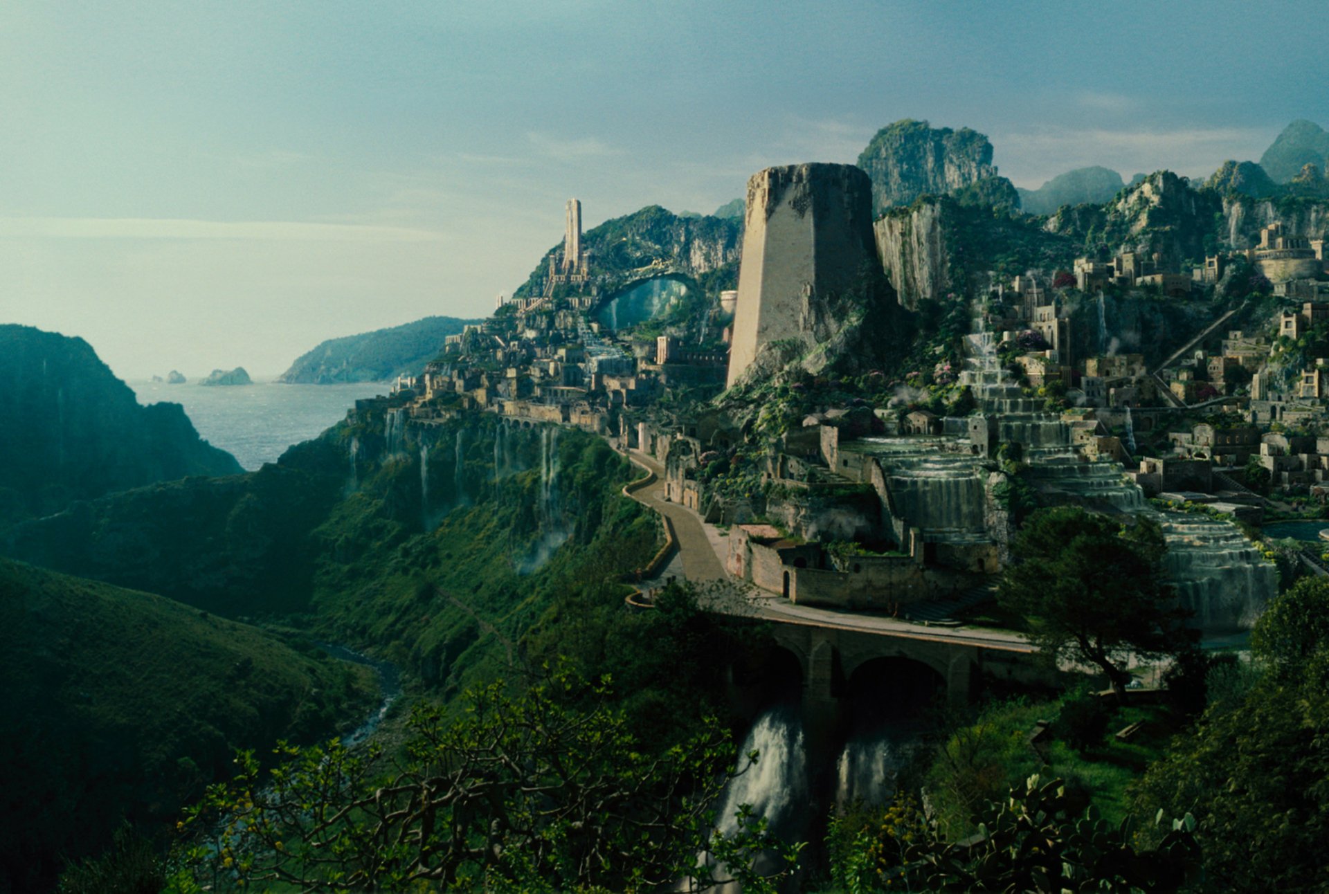 HD desktop wallpaper of a scenic landscape from the movie Wonder Woman, featuring a majestic city built on cliffs with a lush, green valley below. The image serves as a background.