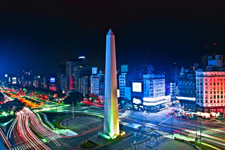 Nighttime time-lapse of Buenos Aires featuring the illuminated Obelisk, surrounding buildings, and busy roads, captured in an HD desktop wallpaper format.