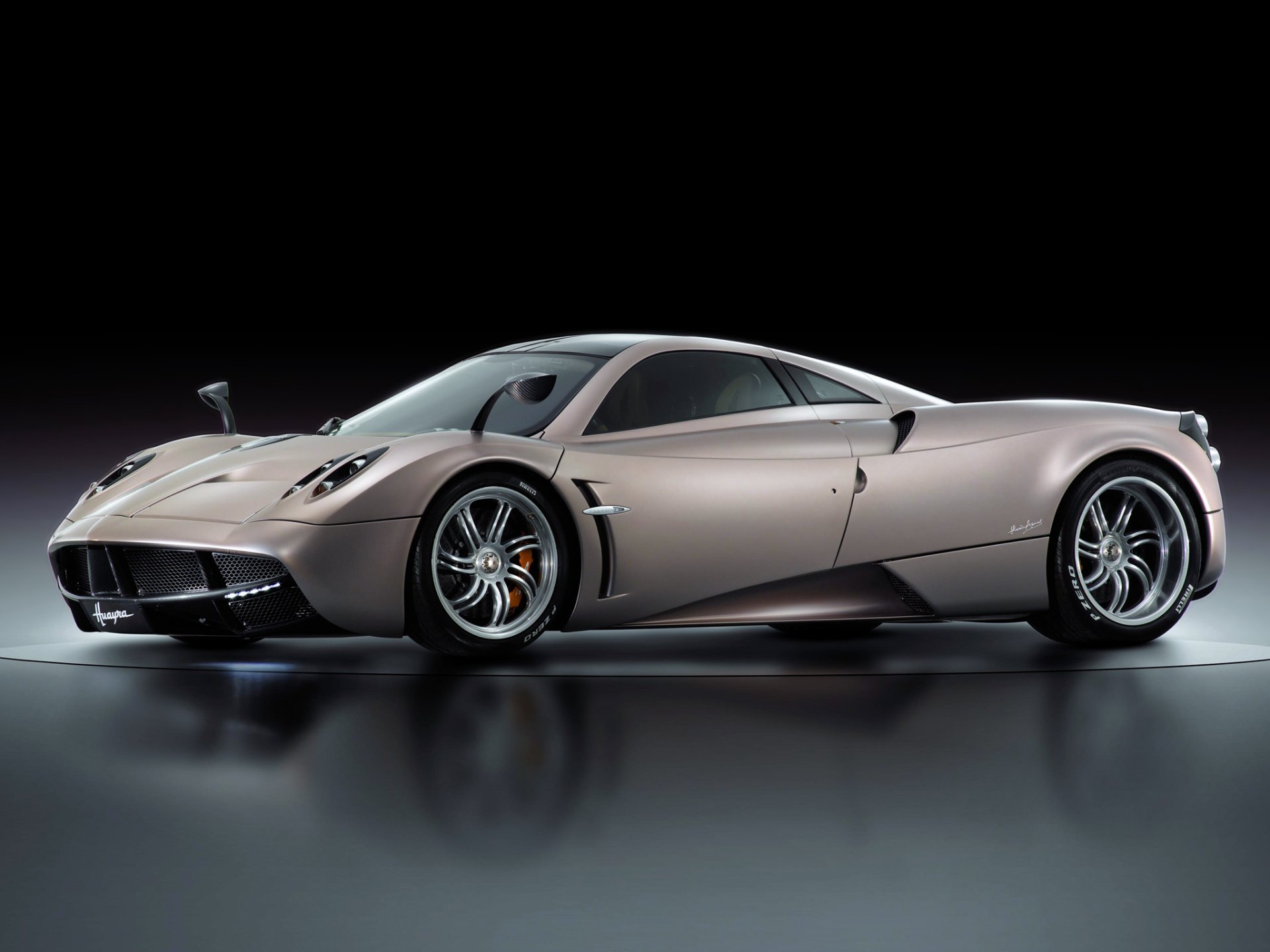 HD desktop wallpaper featuring a sleek Pagani Huayra supercar coupe with a metallic finish, showcasing its aerodynamic design and luxury vehicle details.