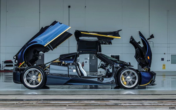 A sleek Pagani Huayra supercar with open doors and panels, showcased in a clean, industrial garage setting as a high-definition PC desktop wallpaper.