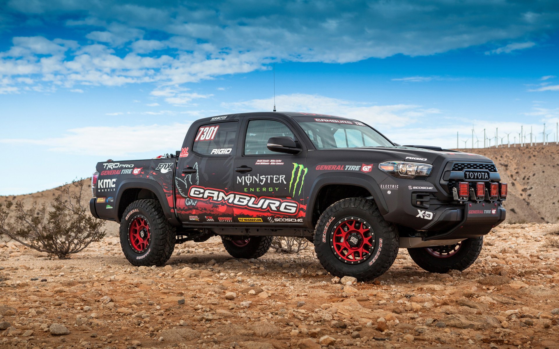 2K Quad HD desktop wallpaper of a Toyota Tacoma TRD Pro race truck vehicle with Monster Energy livery on desert terrain.