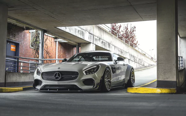 Silver Mercedes-Benz SLS AMG supercar parked in an urban concrete structure, showcasing sleek design and performance, featured as an HD desktop wallpaper background.