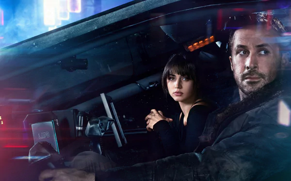 HD desktop wallpaper featuring Ana de Armas as Joi and Ryan Gosling as Officer K from the movie Blade Runner 2049. The two characters are sitting in a futuristic car with neon city lights in the background.
